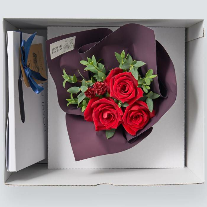 お菓子とバラのアレンジメントが入った箱