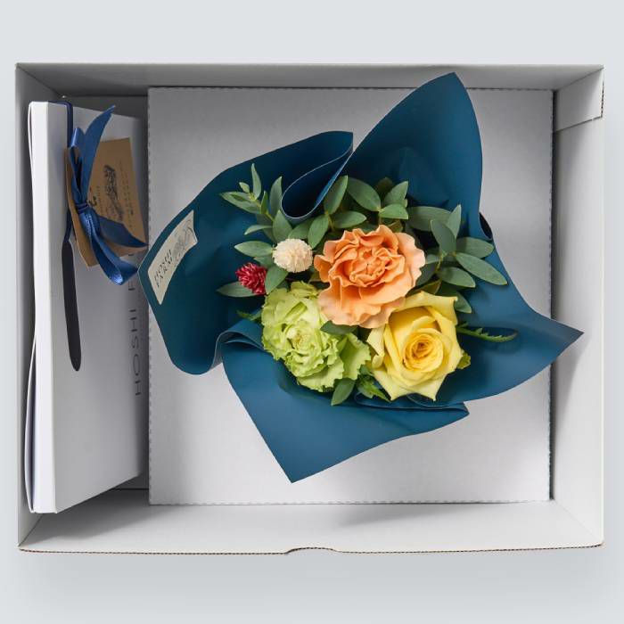 お菓子とバラのアレンジメントが入った箱