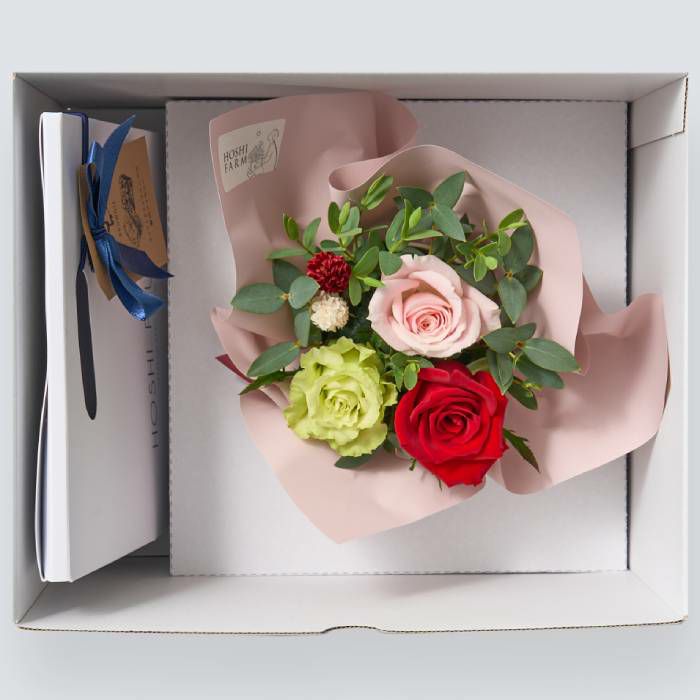 お菓子とバラのアレンジメントが入った箱