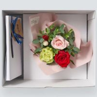 お菓子とバラのアレンジメントが入った箱