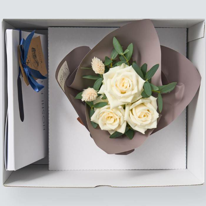 お菓子とバラのアレンジメントが入った箱